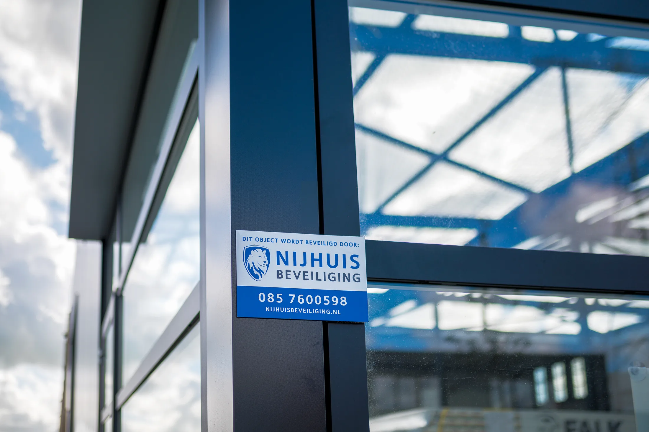 Bord van Nijhuis Beveiliging aan het hek van een bouwplaats